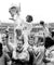 Black and white photo of a group of people celebrating with a trophy, likely a sports team.