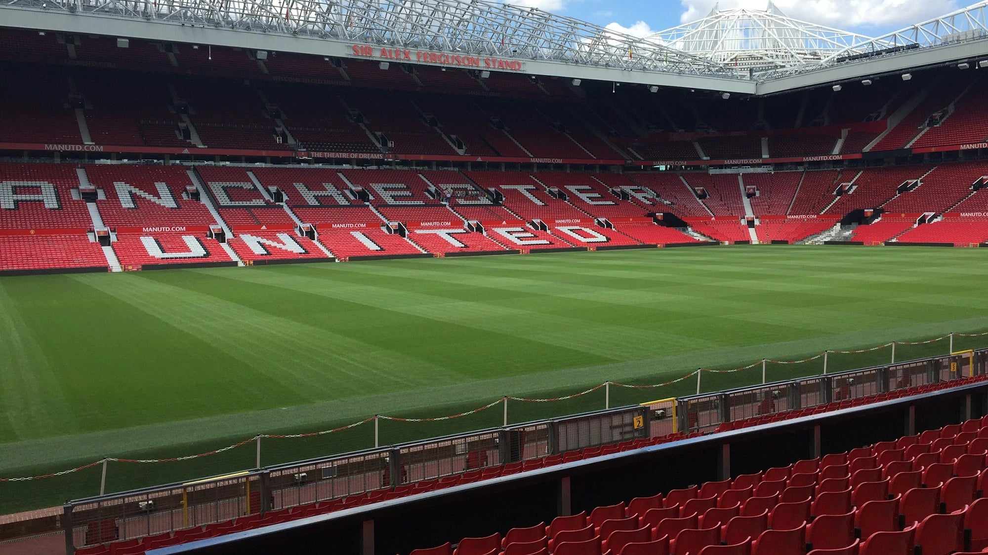 Empty football stadium with 'Manchester United' branding on the seats