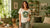 A woman wearing a scoop neck women's organic t-shirts with a song bird graphic print on the chest.